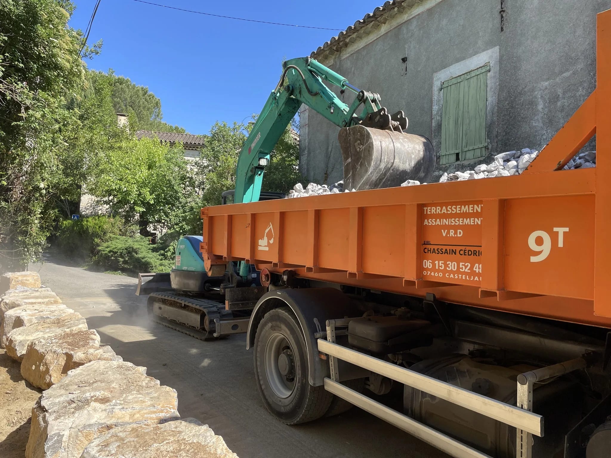 Pelle Chassain TP chargeant une benne sur un chantier